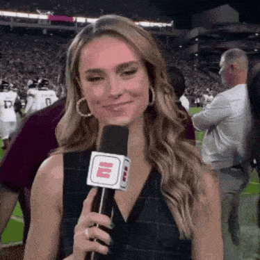 a woman is holding a microphone with the letter e on it ..