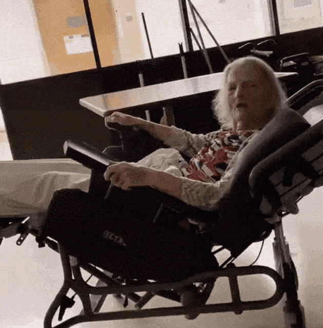 an elderly woman is sitting in a wheelchair with a shirt that says ' uk '