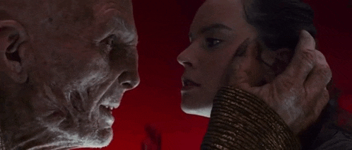 a man and woman are looking at each other in a dark room