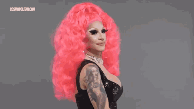 a woman in a pink wig and a black dress is on a cosmopolitan.com advertisement