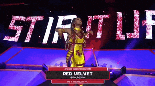 a woman in a yellow and red outfit is on a stage with the name red velvet on it
