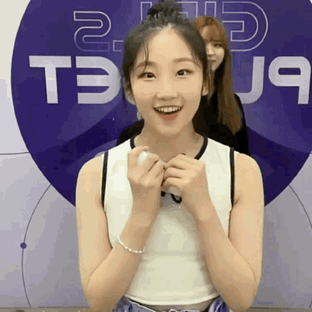 a girl is smiling in front of a purple circle that says t9 on it