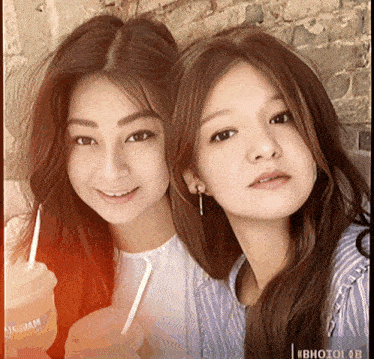 two girls are standing next to each other and one of them is holding a cup that says ' avocado jam ' on it