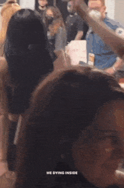 a group of people are standing in a room with a man in a mask .