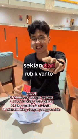 a young man sitting at a table pointing at the camera with the words " sekian dari rubik yanto " on the bottom