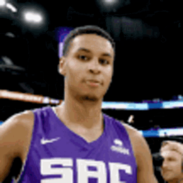 a basketball player wearing a purple jersey with the letter sbc on it