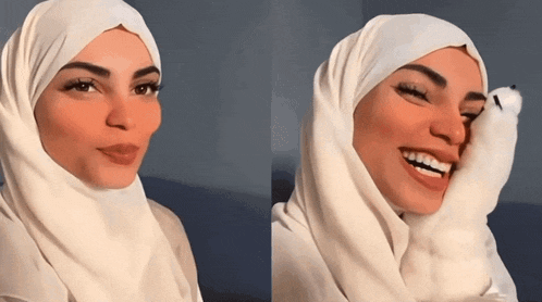 a woman wearing a white hijab is smiling and holding a stuffed animal