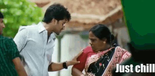 a man is putting his hand on a woman 's shoulder while talking to her .