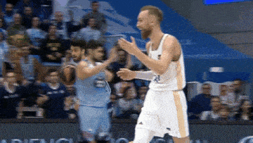 a basketball player with the number 21 on his jersey stands on the court
