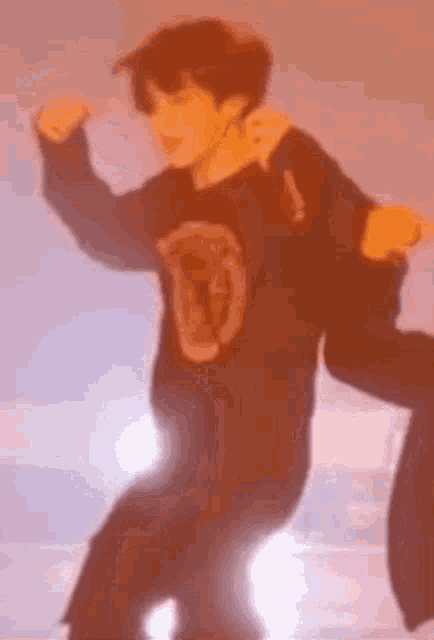 a man in a black shirt is dancing on a stage with his arms outstretched .