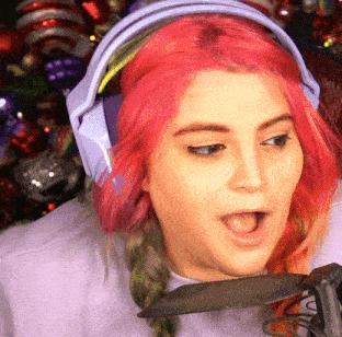 a woman with pink hair is wearing headphones and holding a knife in her mouth .