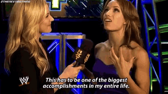 two women are talking to each other in front of a microphone and one of them is talking about her accomplishments in her entire life