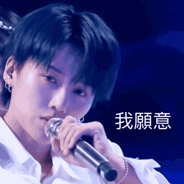 a close up of a person holding a microphone with chinese characters on it