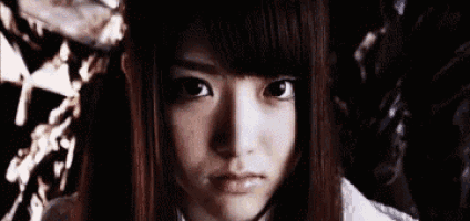 a close up of a girl 's face in a dark room .