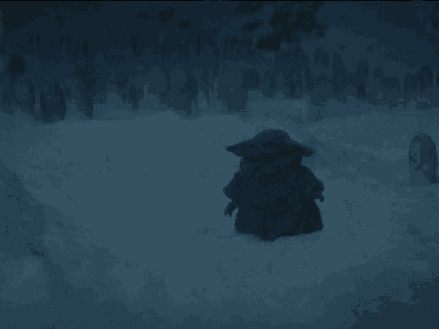 a baby yoda is walking through a snowy cemetery at night