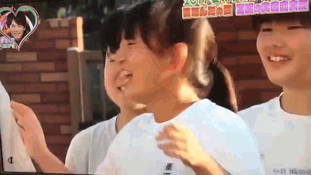 a group of young girls are on a tv screen with the number 1 on the bottom right