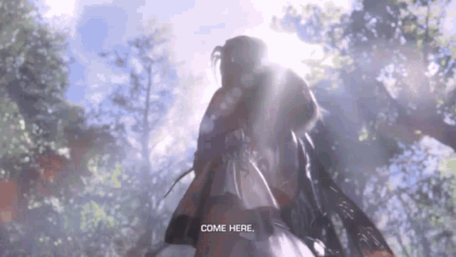 a woman is standing in the woods with the sun shining through the trees and says come here .