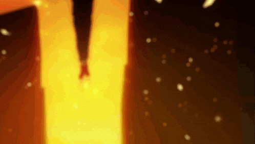 a blurry picture of a person walking through a doorway with fire coming out of it .