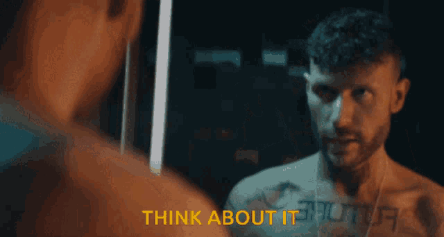 a shirtless man is looking at himself in a mirror with the words think about it visible