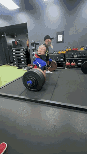 a man lifting a barbell in a gym with a motorcycle in the background