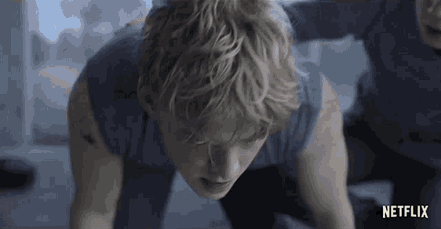 a man is doing push ups with a netflix logo in the corner