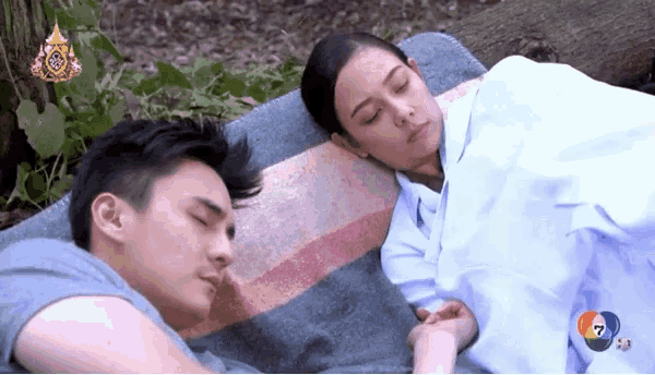 a man and a woman laying on a blanket with the number 7 on the bottom left