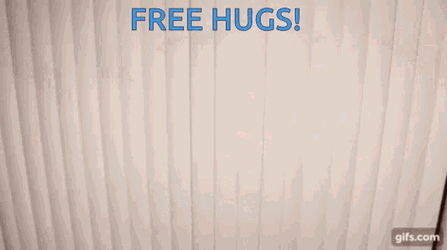 a man wearing glasses and a blue shirt is holding his arms in the air with the words free hugs behind him
