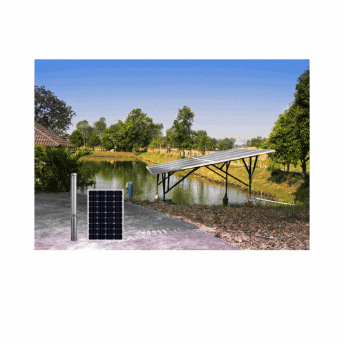 a man is standing next to a solar panel in front of a lake