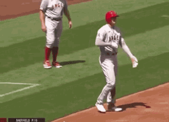 a baseball player is standing on a baseball field with a referee .