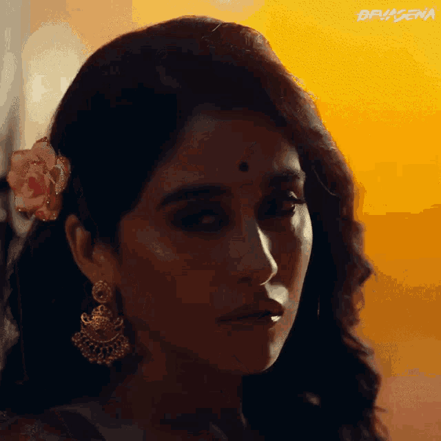 a close up of a woman 's face with a flower in her hair and the word devagena on the bottom