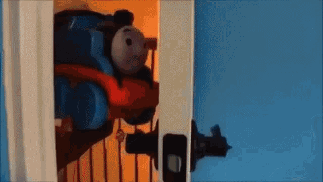 a toy train is coming out of a doorway .