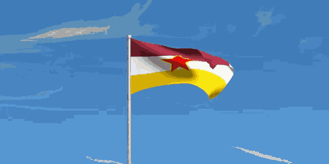 a red white and yellow flag with a red star is waving in the wind