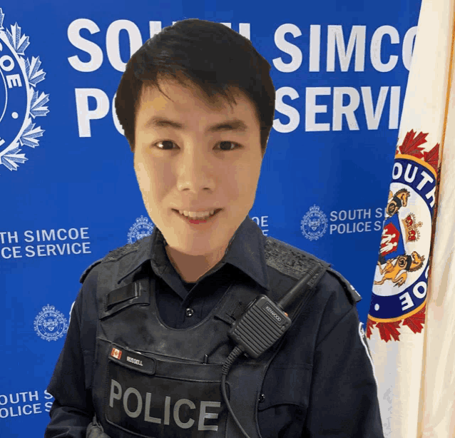 a man in a police uniform stands in front of a south simcoe police sign