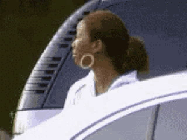 a woman with hoop earrings is sitting in a white car .