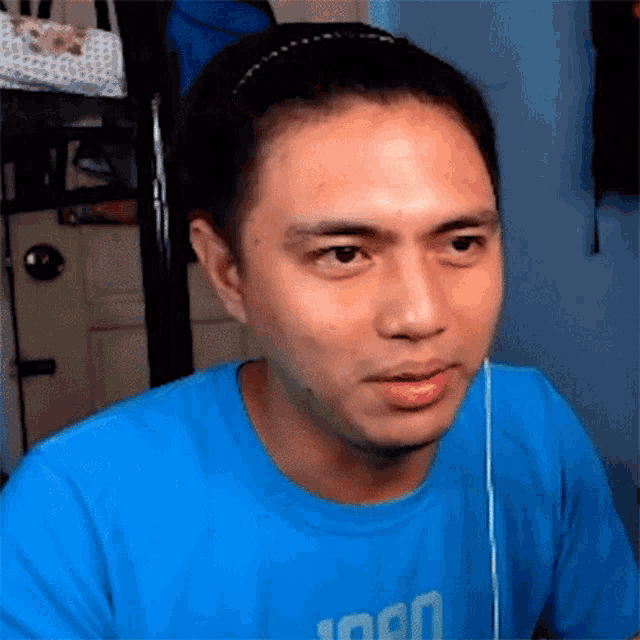 a man wearing a headband and a blue shirt that says ' 1000 ' on it