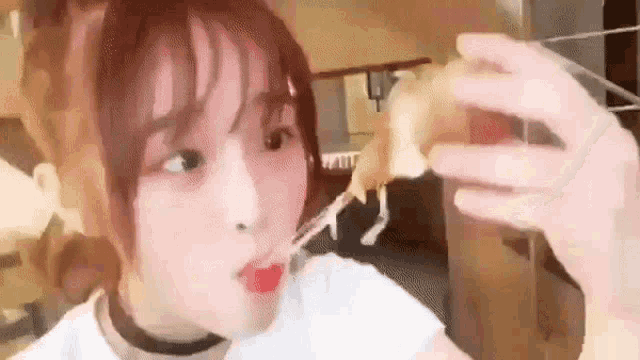 a woman is taking a selfie with her phone while eating a piece of pizza .