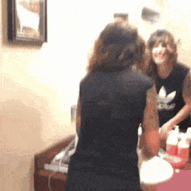 a woman in an adidas shirt is looking at herself in a bathroom mirror