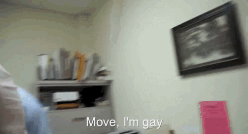 a blurry photo of a room with the words move i 'm gay