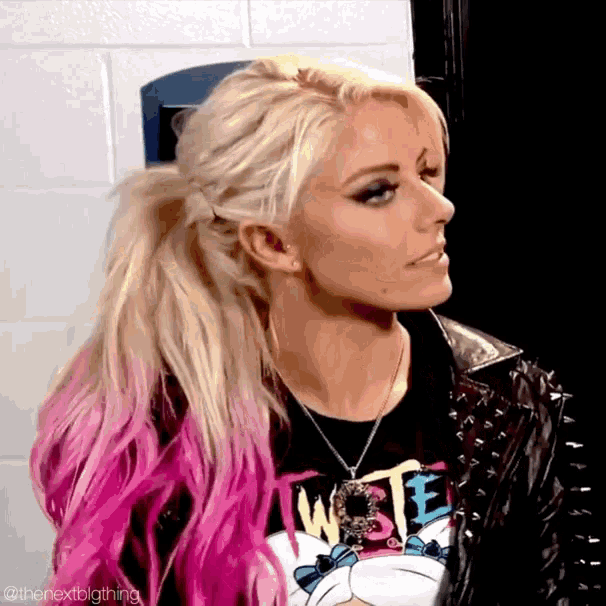 a woman with blonde and pink hair is wearing a t-shirt that says twiste