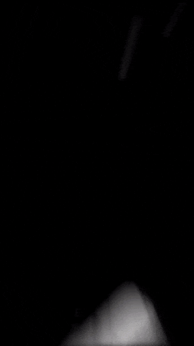 a black and white photo of a light coming out of a dark room