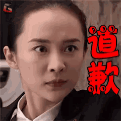 a woman in a suit and tie is making a funny face with chinese writing on her face .