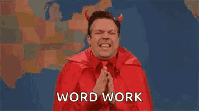 a man dressed as a devil with horns is making a funny face and saying `` word work '' .