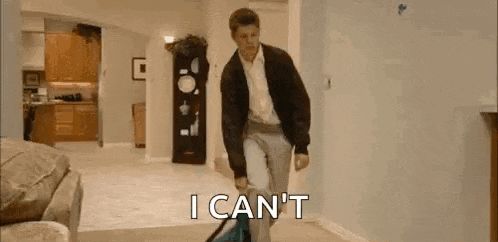 a man is using a vacuum cleaner in a living room and saying `` i can t '' .