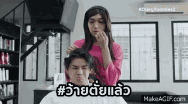 a man is getting his hair cut by a woman in a pink shirt with the hashtag #diarytootsies2