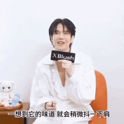 a man in a white shirt is holding a sign that says x blush .
