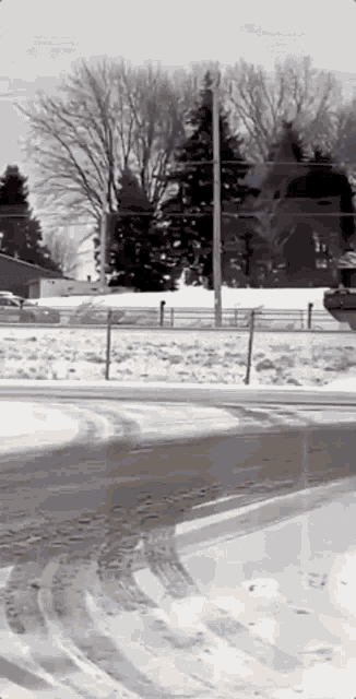 a car is driving down a snowy road with a red car in the background .