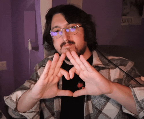 a man making a heart shape with his hands