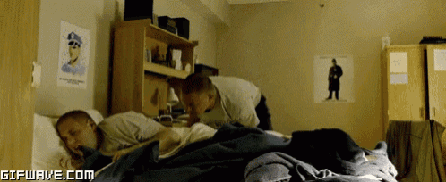 two men are sleeping in a dorm room with a gifwave.com logo in the corner