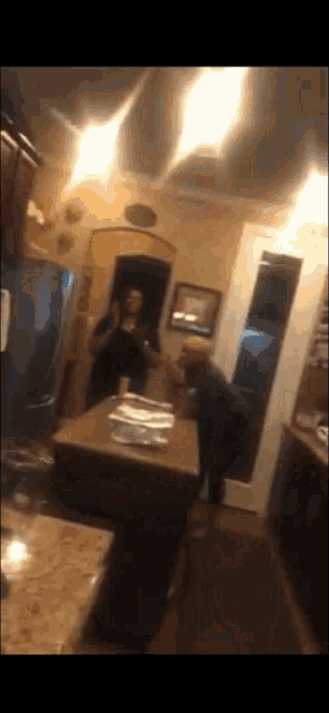 a blurry photo of a man and a woman standing in a kitchen