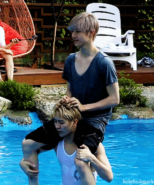 a man is carrying another man on his back in a pool